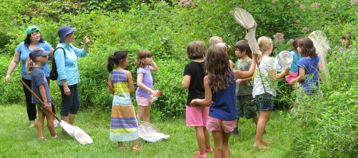 Children talking with an adult during an outdoor nature program.