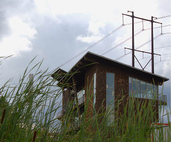 Small building beside a wetland with power lines overhead.